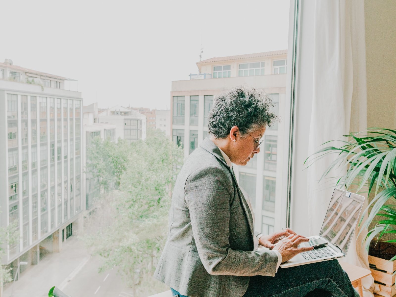 Executive working at a laptop by a window